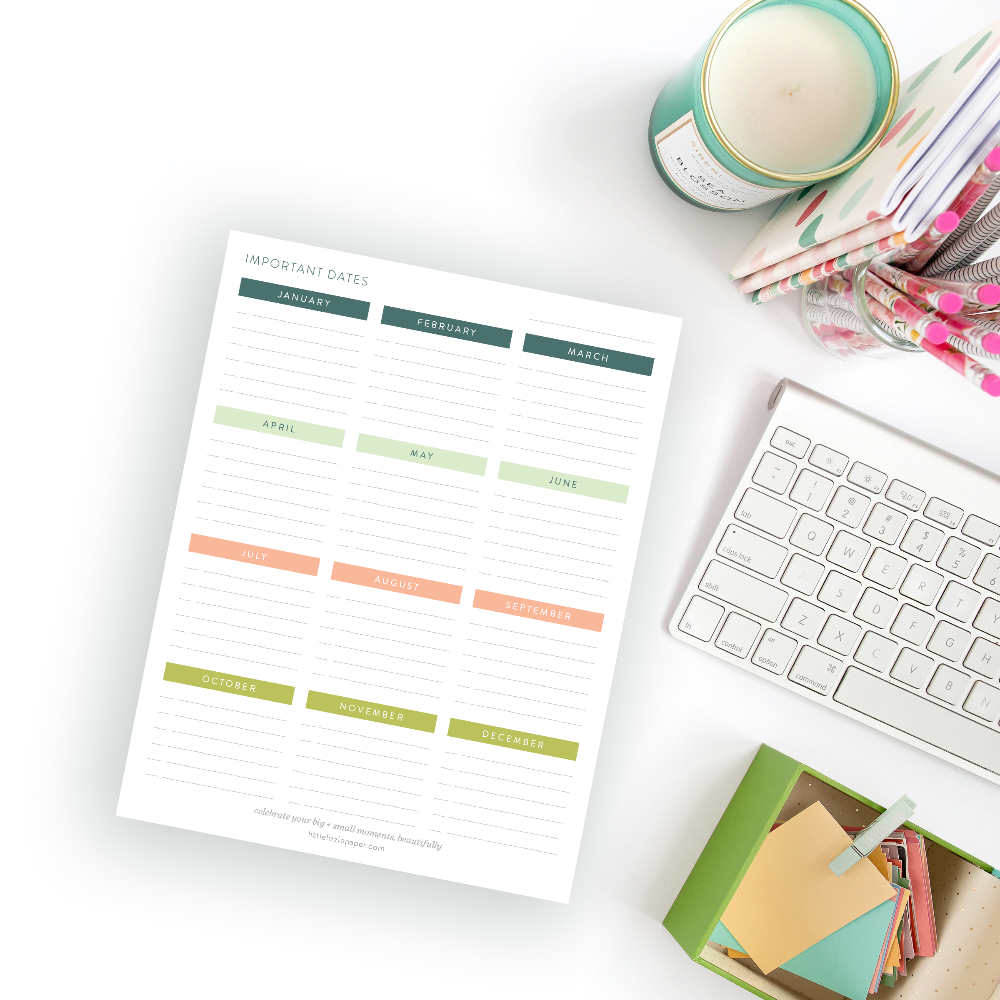 Colorful planner sheet on a desk with a laptop and stationery items.