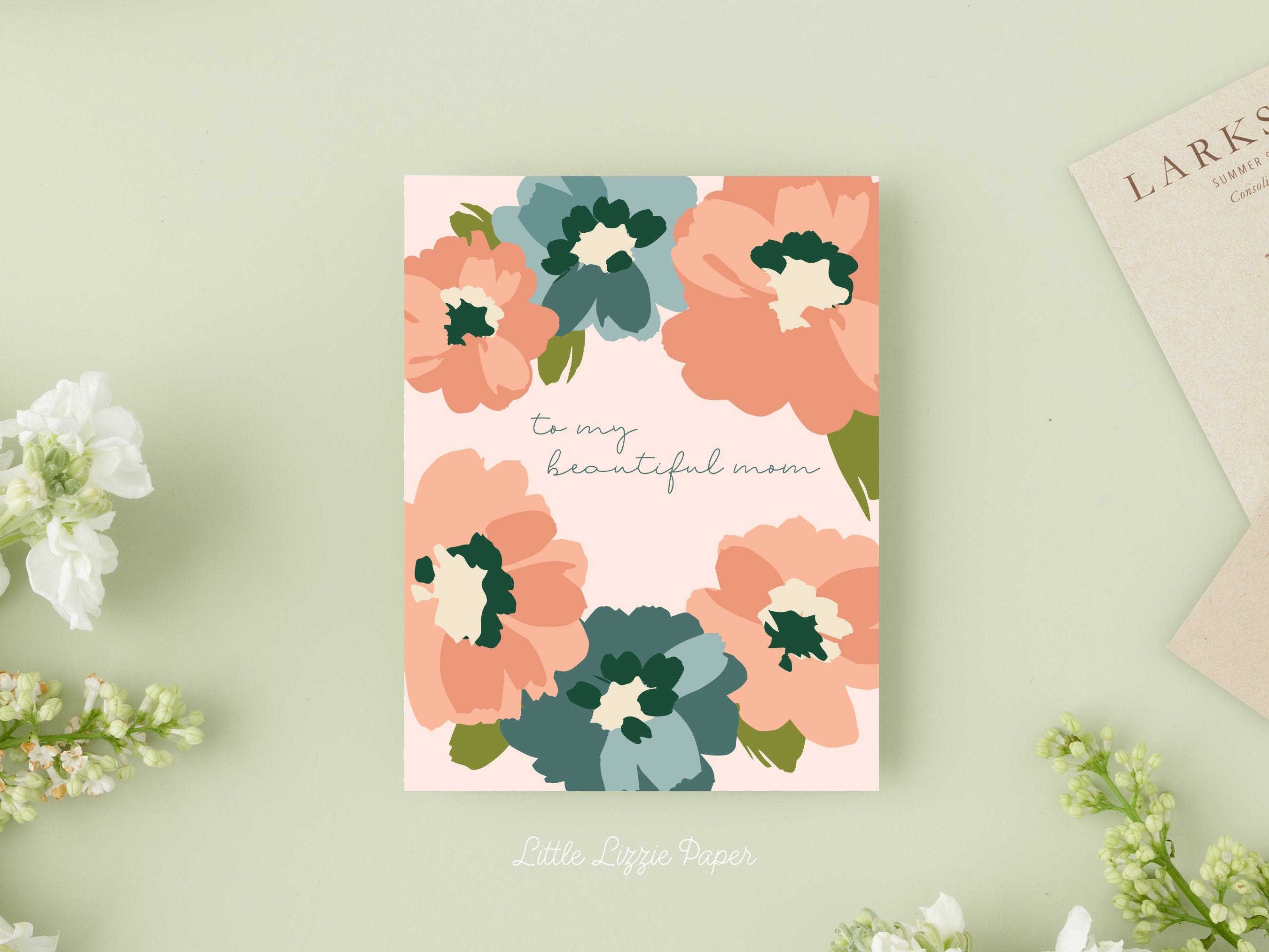 Mothers Day card that reads To My Beautiful Mom in the middle with pink and blue flowers around the outside edges on a blush background.